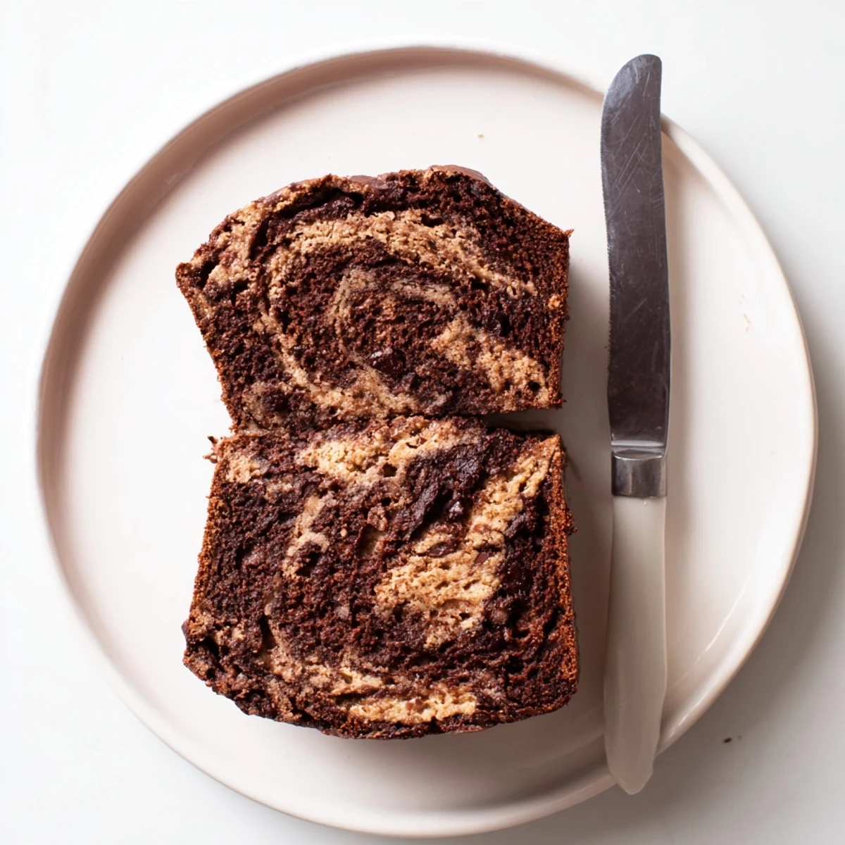 Sliced chocolate peanut butter banana bread showing moist crumb with melted chocolate chips and peanut butter swirls on a wooden cutting board