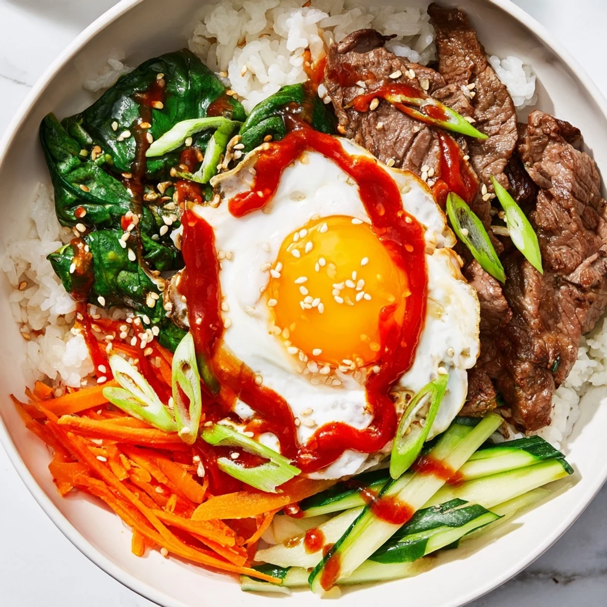 Steaming white rice bowl topped with marinated beef, fresh vegetables, and fried egg drizzled with spicy gochujang sauce