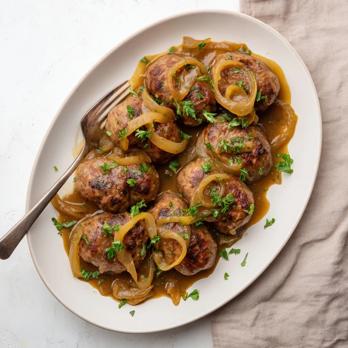 Savory pork sausages nestled in a thick, flavorful onion gravy sauce with melted butter richness