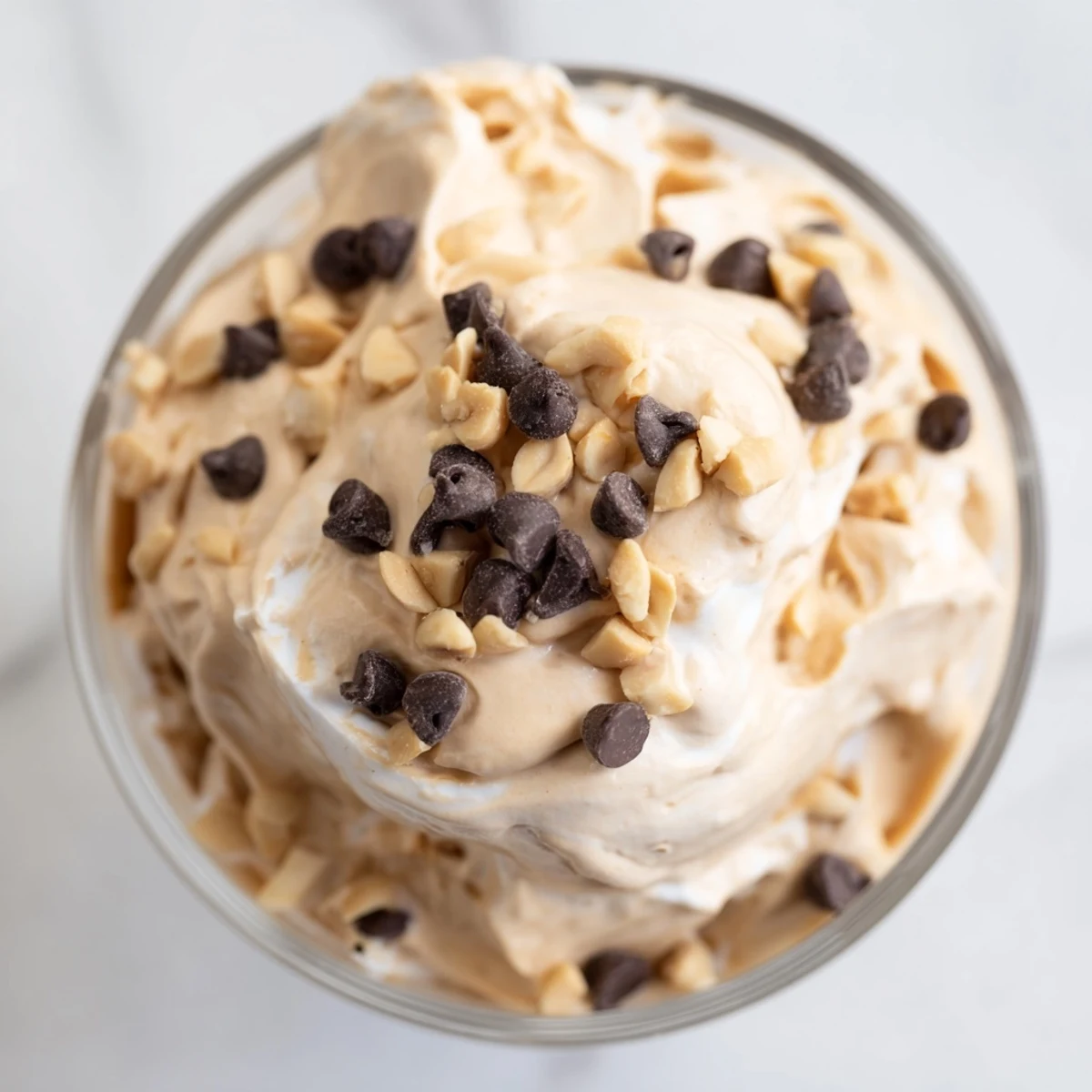 Light and fluffy peanut butter mousse dessert swirled with whipped topping and garnished with peanut pieces