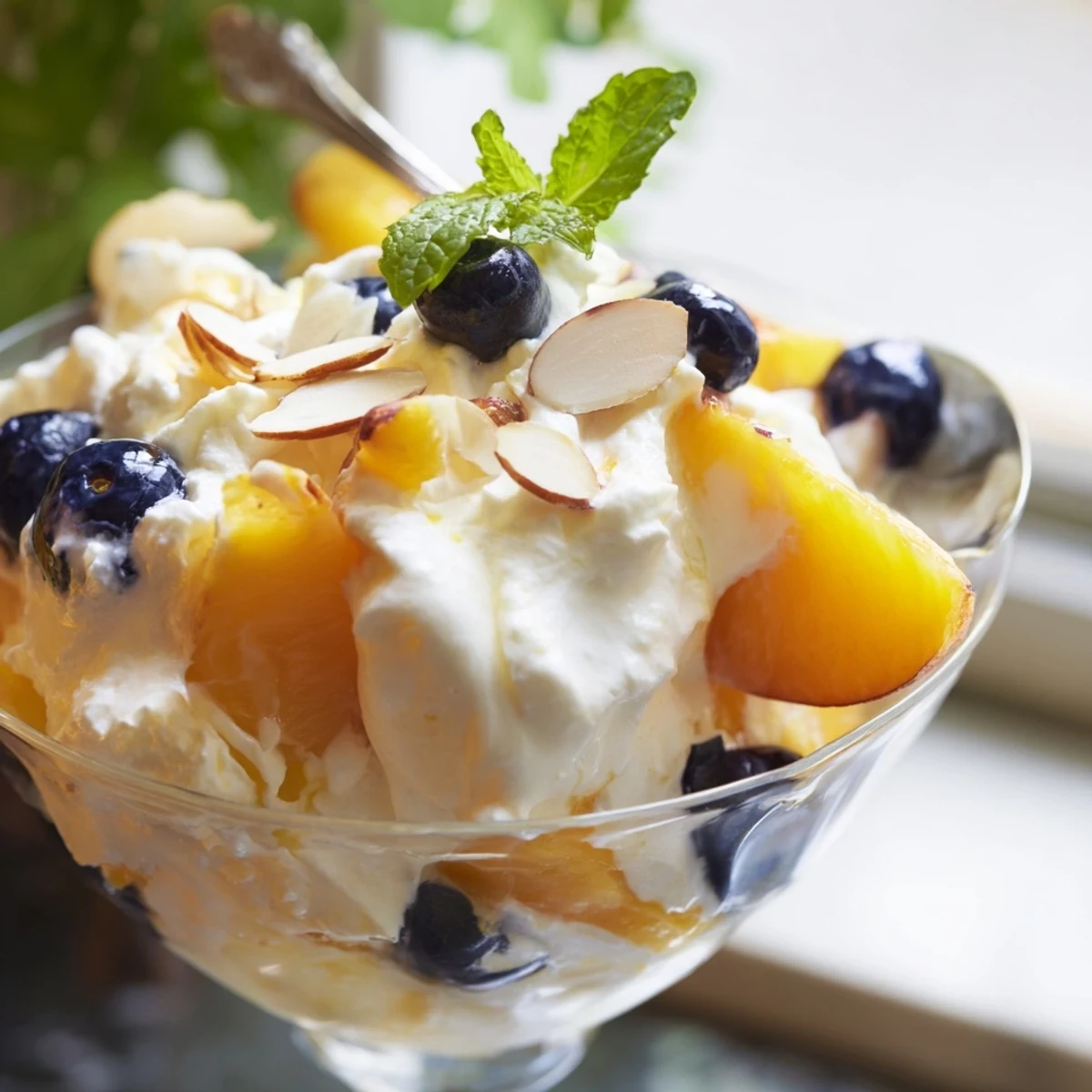 Creamy peaches and cream salad topped with fresh mint leaves and juicy ripe peach slices