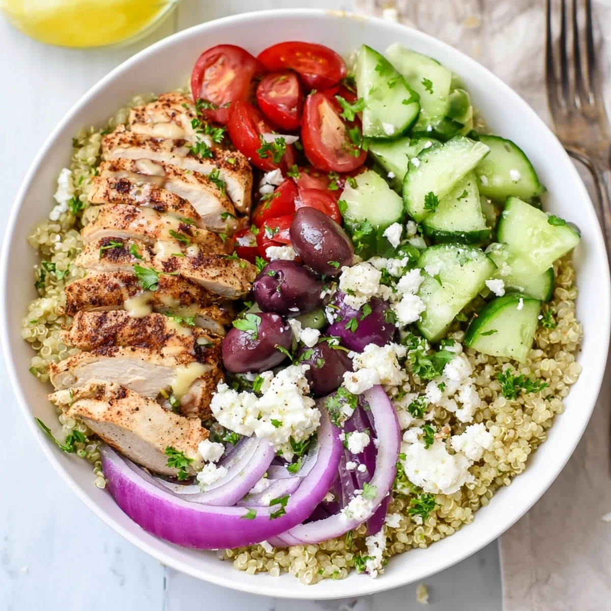Colorful Mediterranean Chicken Quinoa Bowl featuring tender sliced chicken and crisp cucumber tomato salad