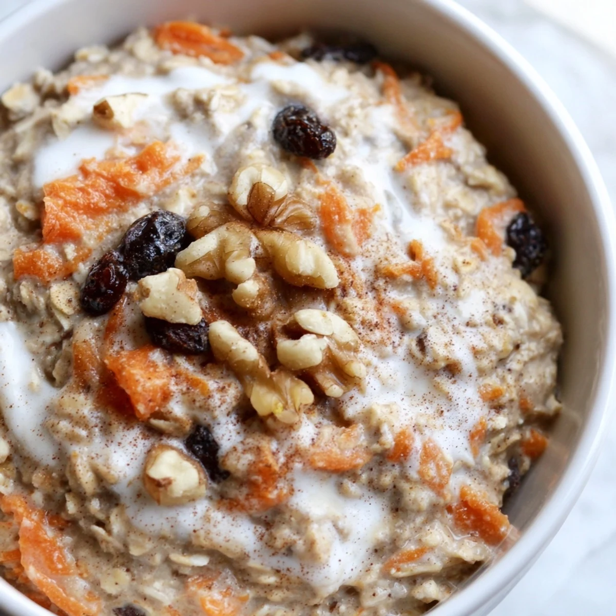 Carrot cake overnight oats with grated carrots, raisins, and a cinnamon sprinkle