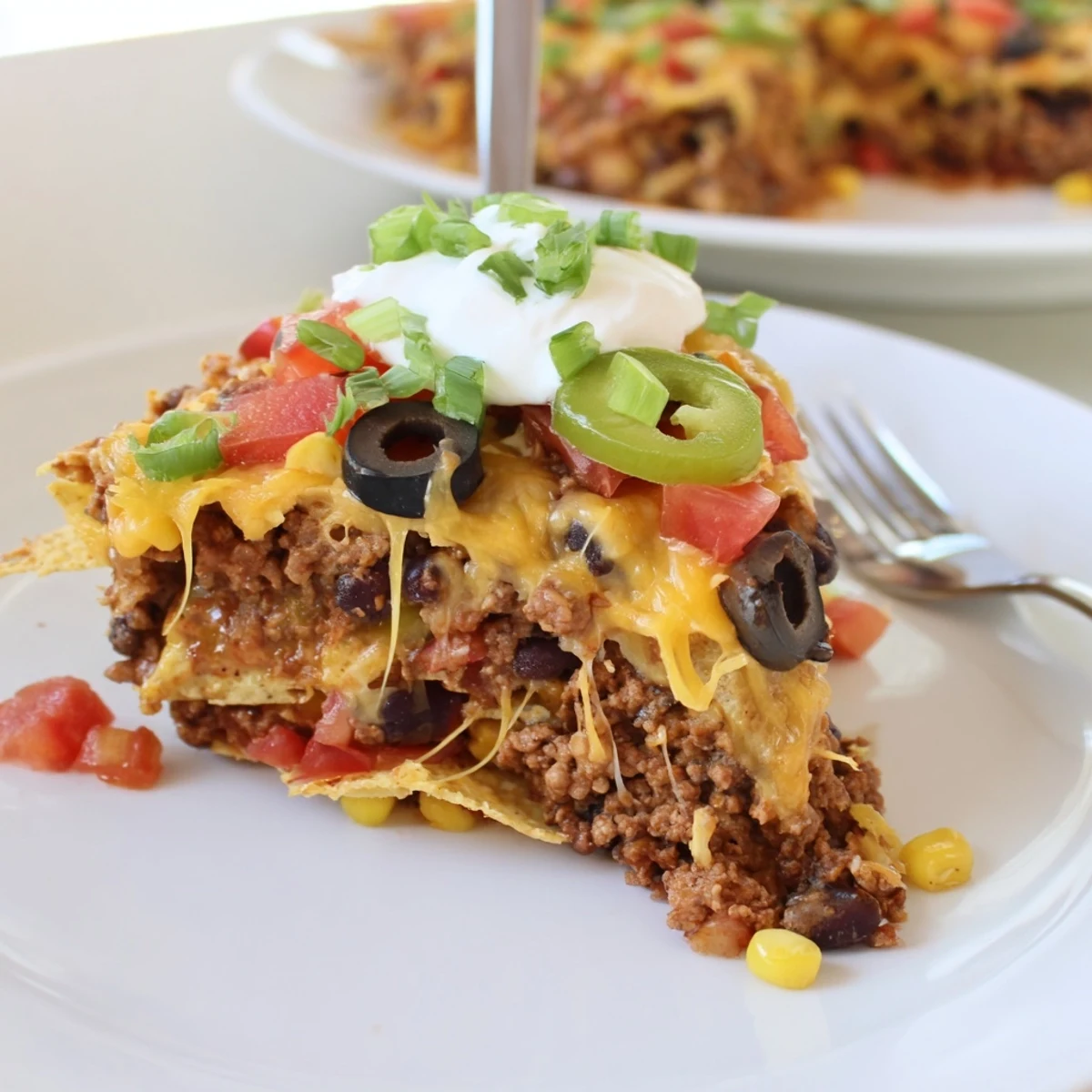 Warm Cheesy Nacho Casserole served with sour cream, cilantro, sliced jalapeños