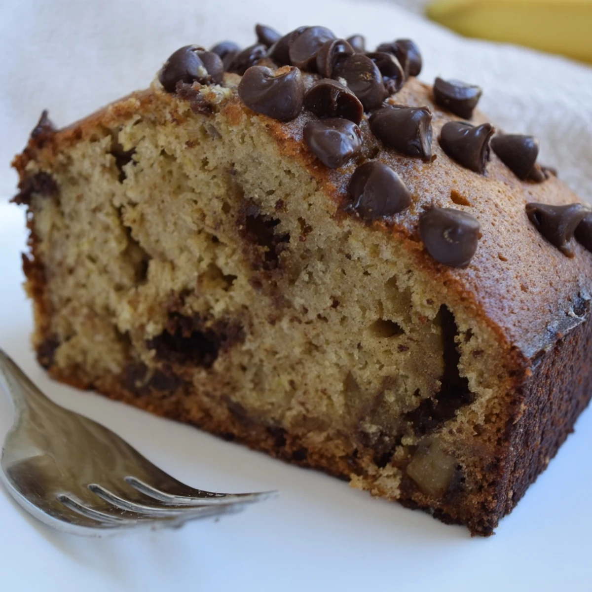 Warm Banana Chocolate Chip Cake sliced on rack, tender crumb, melting chips