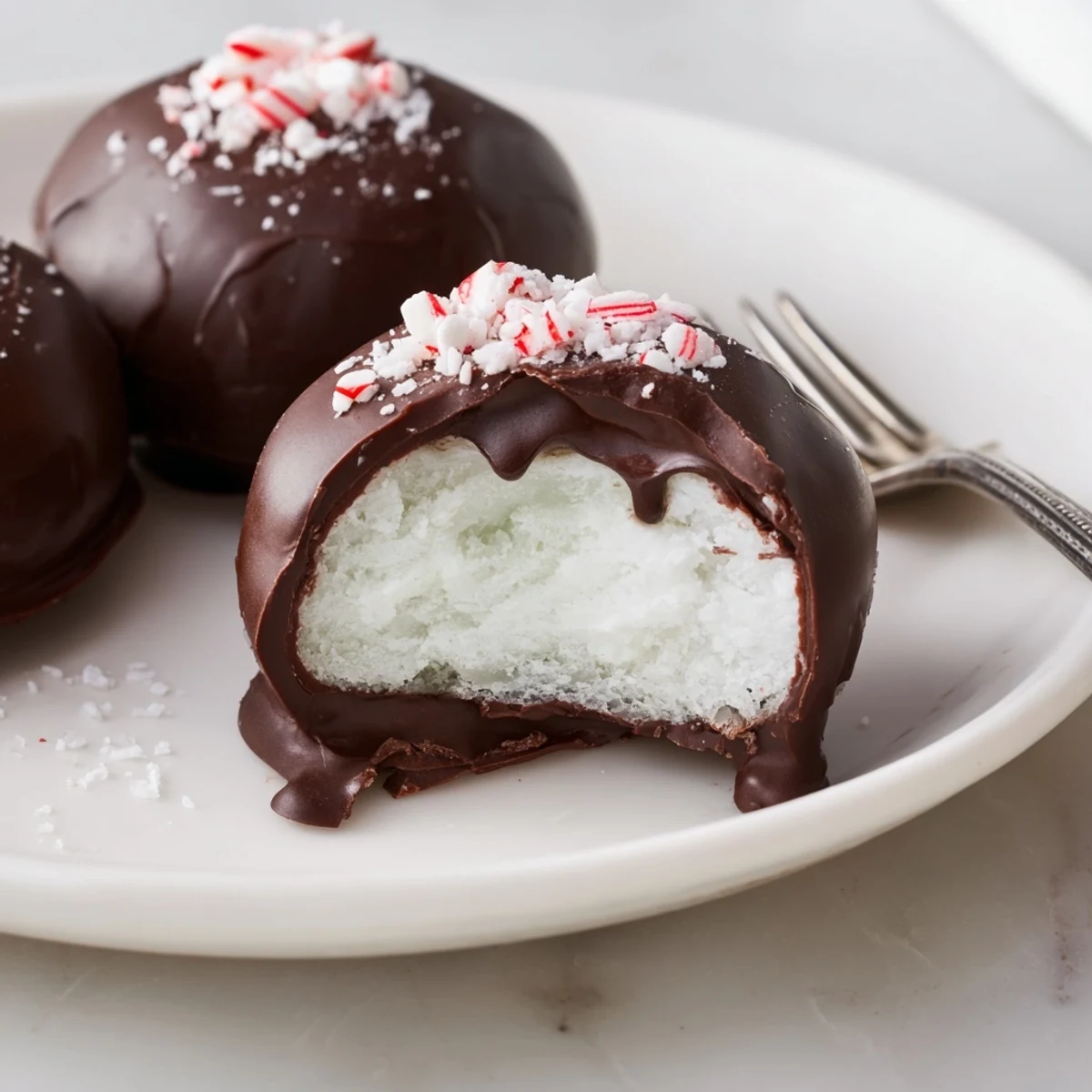 Peppermint Patties resting on parchment, glossy dark chocolate, cool minty filling.