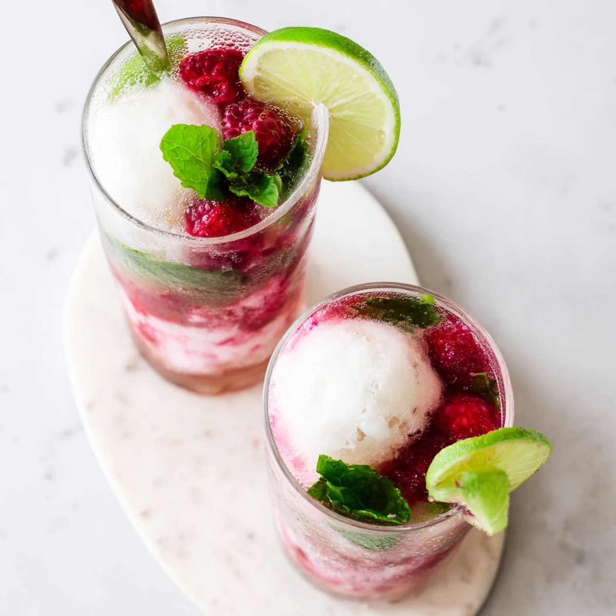 Vibrant raspberry mint mojito float with bubbling soda scoops of vanilla ice cream and mint garnish