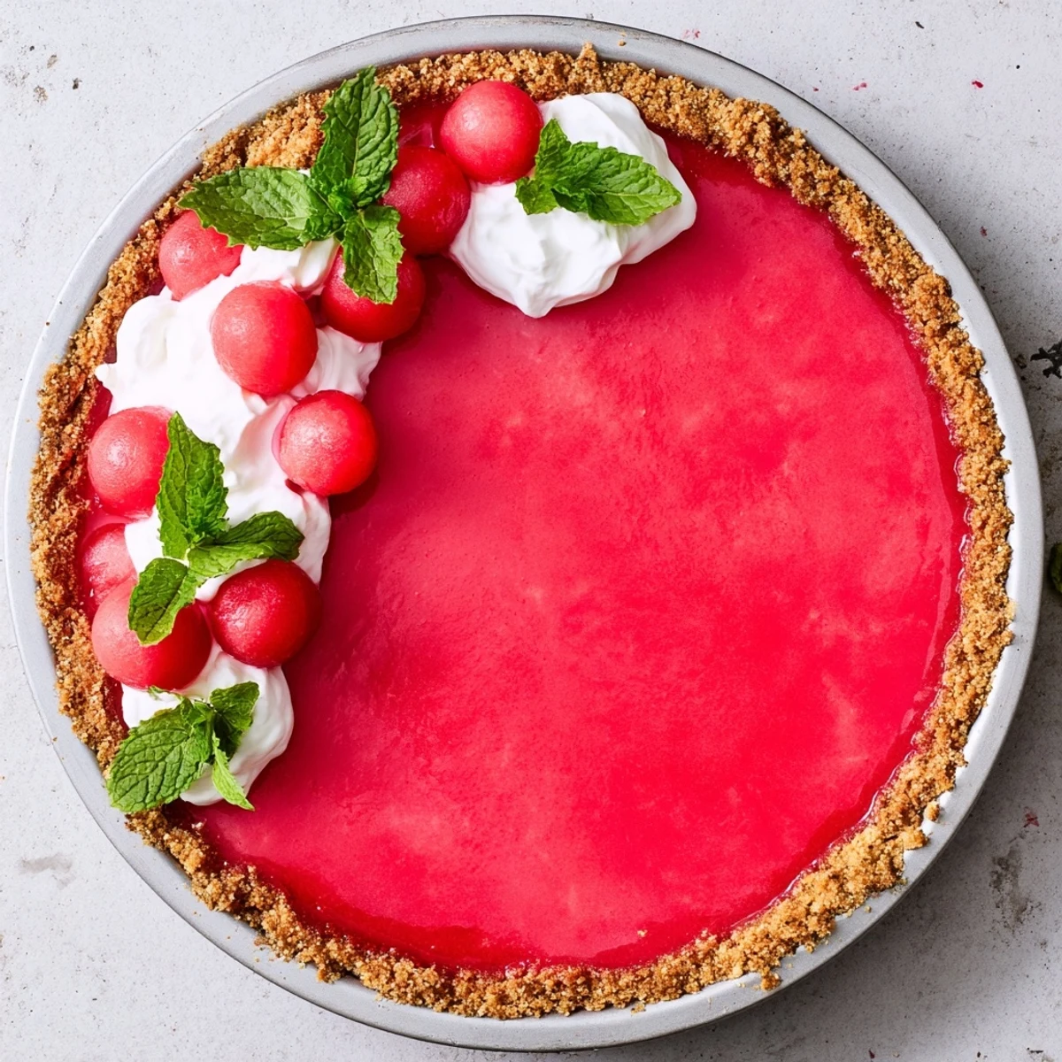 Slice of refreshing watermelon summer pie showing smooth texture and whipped cream garnish on a white serving plate