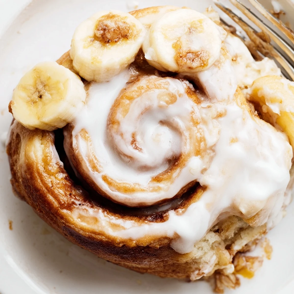 Warm banana cinnamon rolls rising in a baking pan with sweet cinnamon sugar layers