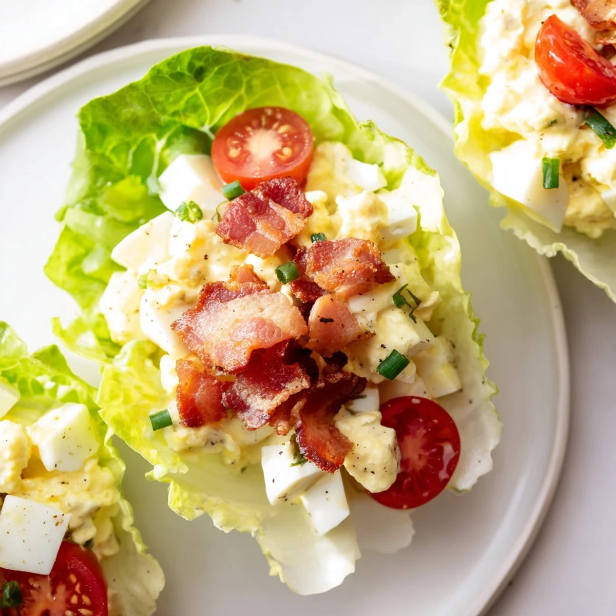 BLT Egg Salad Lettuce Wraps on a wooden board, crisp, creamy filling