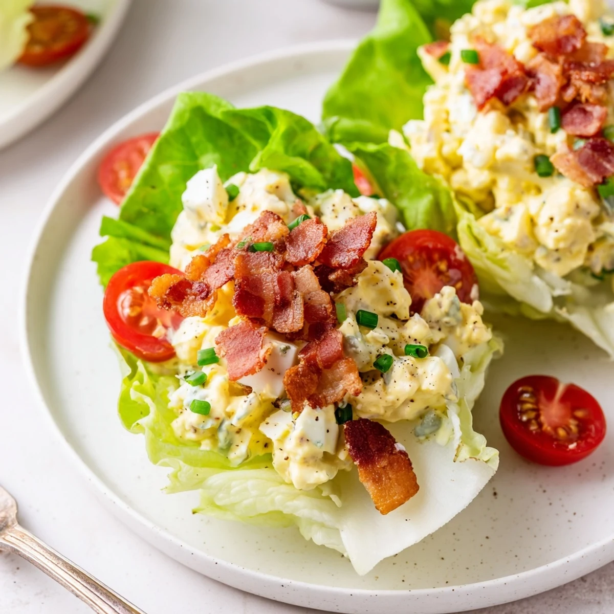 Handheld BLT Egg Salad Lettuce Wraps served with iced tea, bright herbs