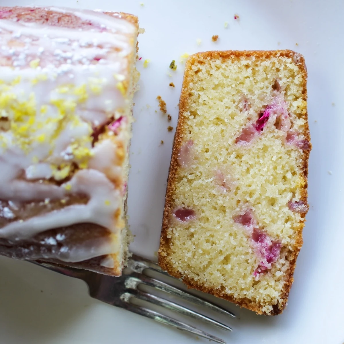 Homemade rhubarb lemon drizzle cake dusted with powdered sugar and fresh zest