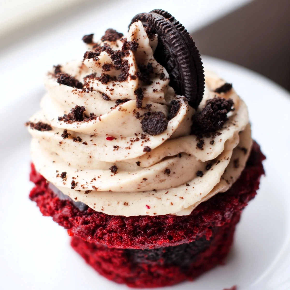 Red Velvet Oreo Cupcakes topped with creamy frosting and scattered cookie crumbs
