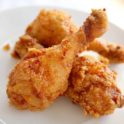 Serve Spicy Honey Butter Fried Chicken hot over buttermilk biscuits and pickles.  